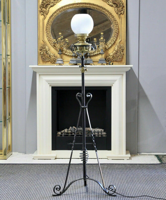 Arts & Crafts wrought iron standard lamp, front view in front of a fireplace