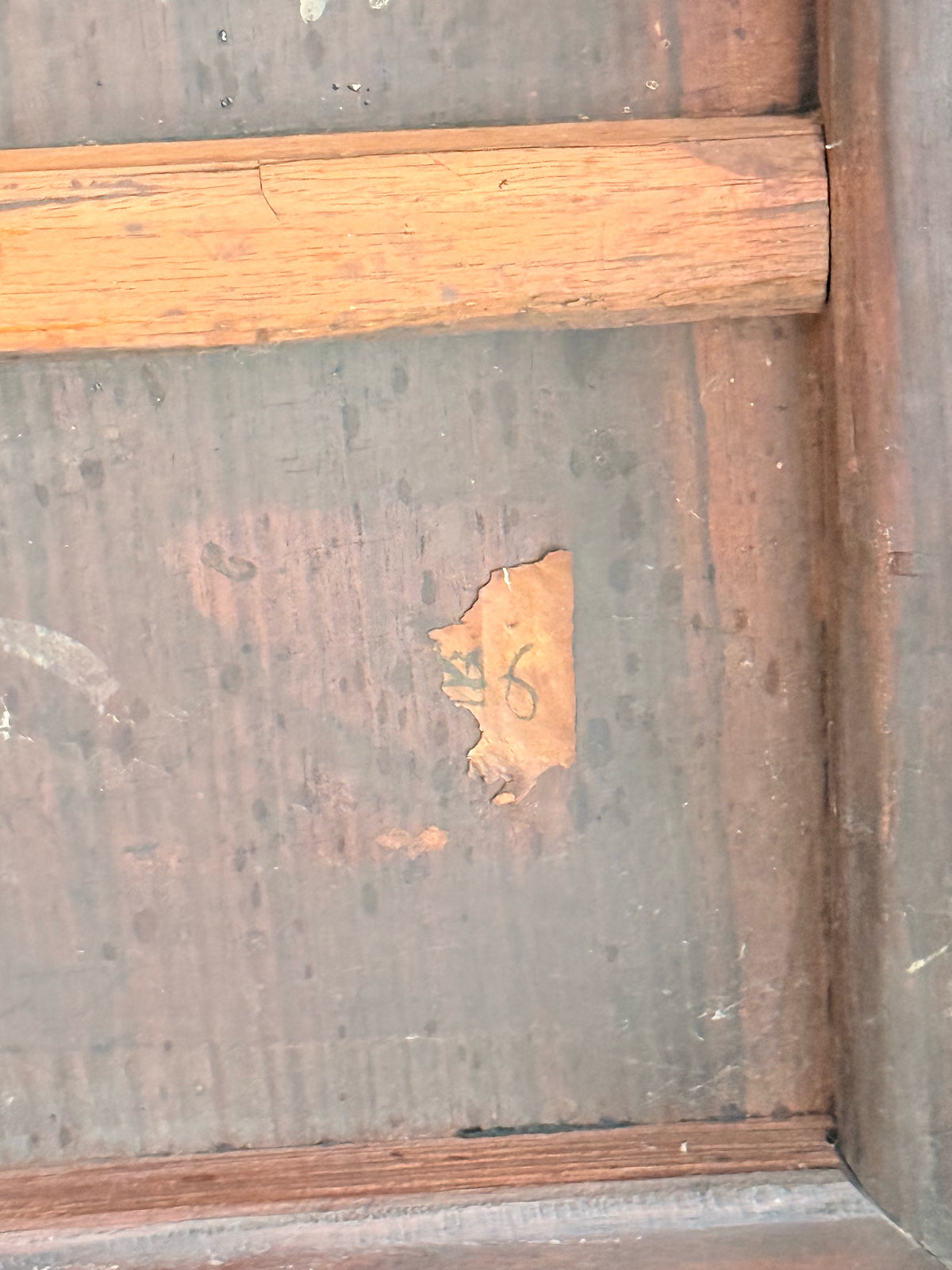 Close-up of the old paper label remnant with handwritten numbers
