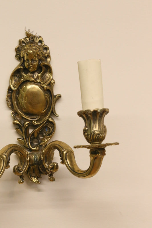 Close-up of cherub crest and scrolled backplate, Italian brass sconce