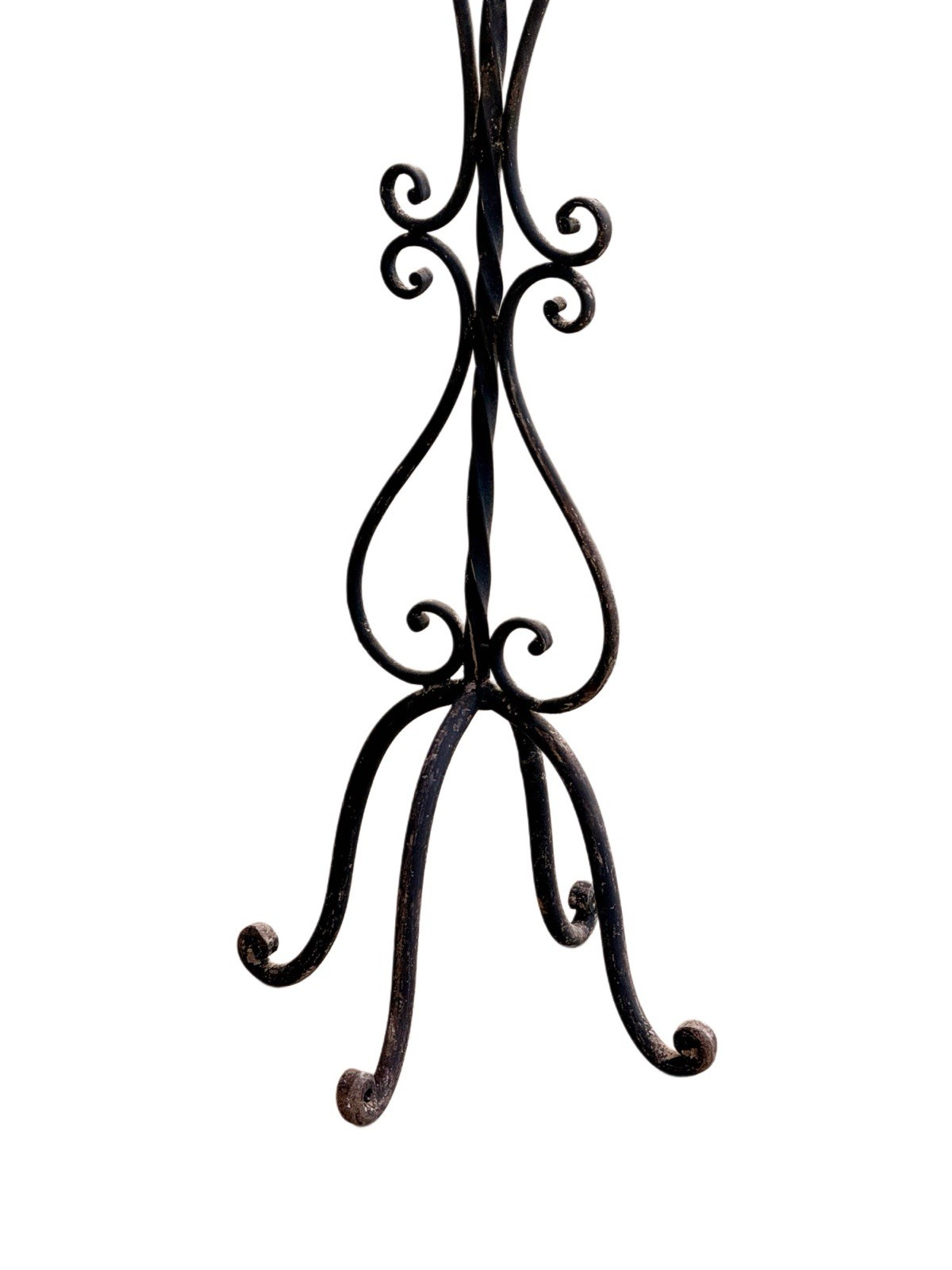Wrought iron candelabra, close-up of scrolled tripod base and feet