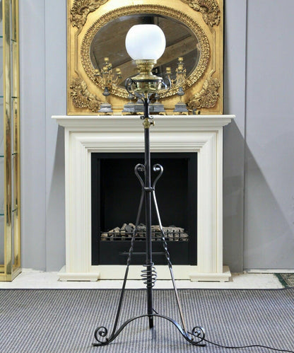 Arts & Crafts wrought iron standard lamp, front view in front of a fireplace