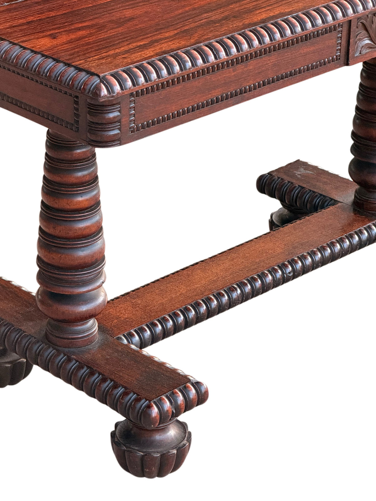 Corner detail of the rosewood table: gadrooned top edge, turned column and gadrooned stretcher