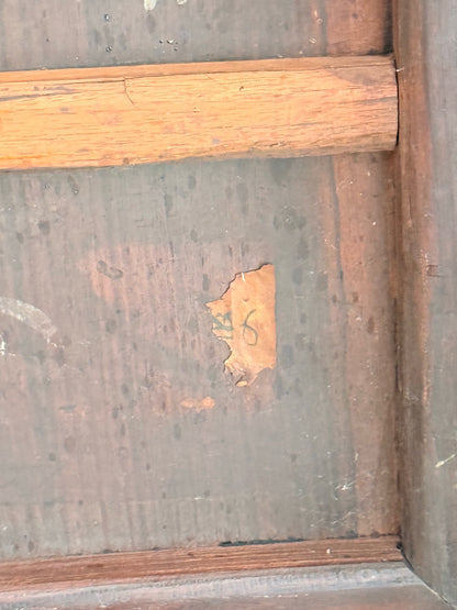 Close-up of the old paper label remnant with handwritten numbers