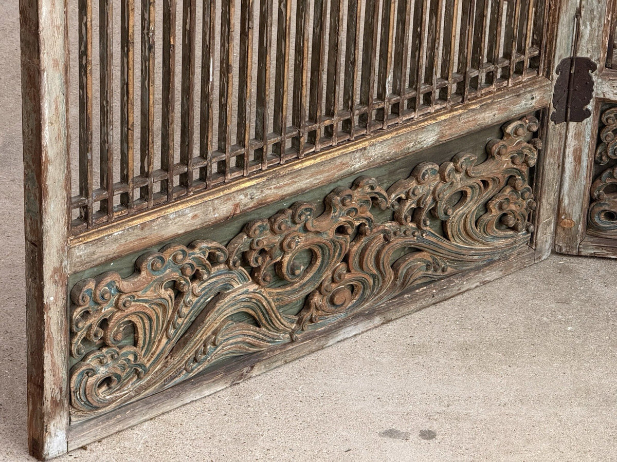 Close-up of carved scrolling wave panel at the base of the lattice screen