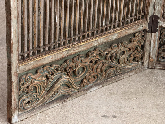 Close-up of carved scrolling wave panel at the base of the lattice screen