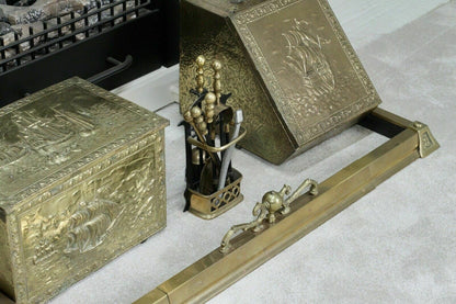 Brass fender in front of a fireplace with coal box and companion set