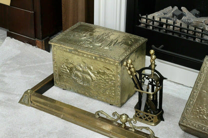 Brass fender detail by a fireplace with embossed coal box