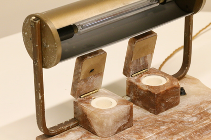Close-up of open alabaster inkwells beneath the brass shade