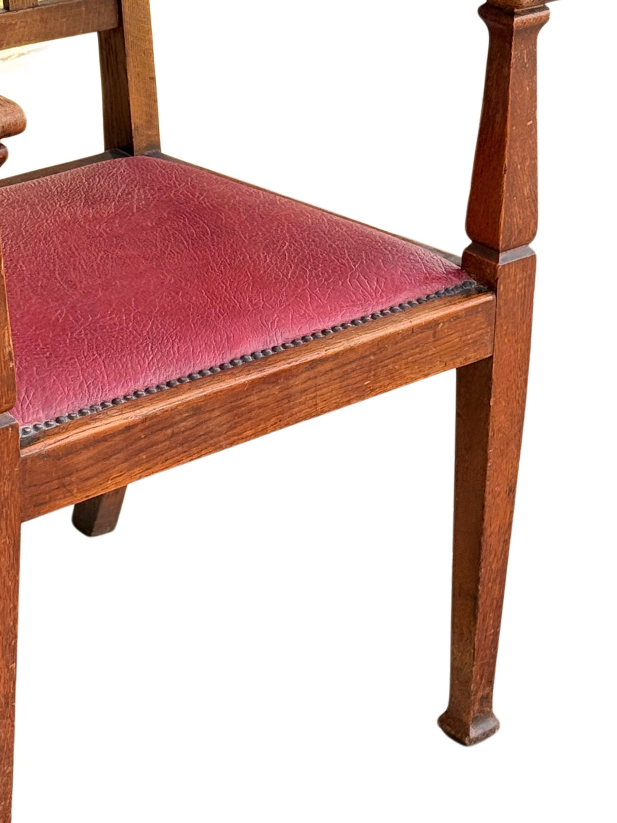 Detail of the red leatherette drop-in seat with stud border and square tapering oak front leg