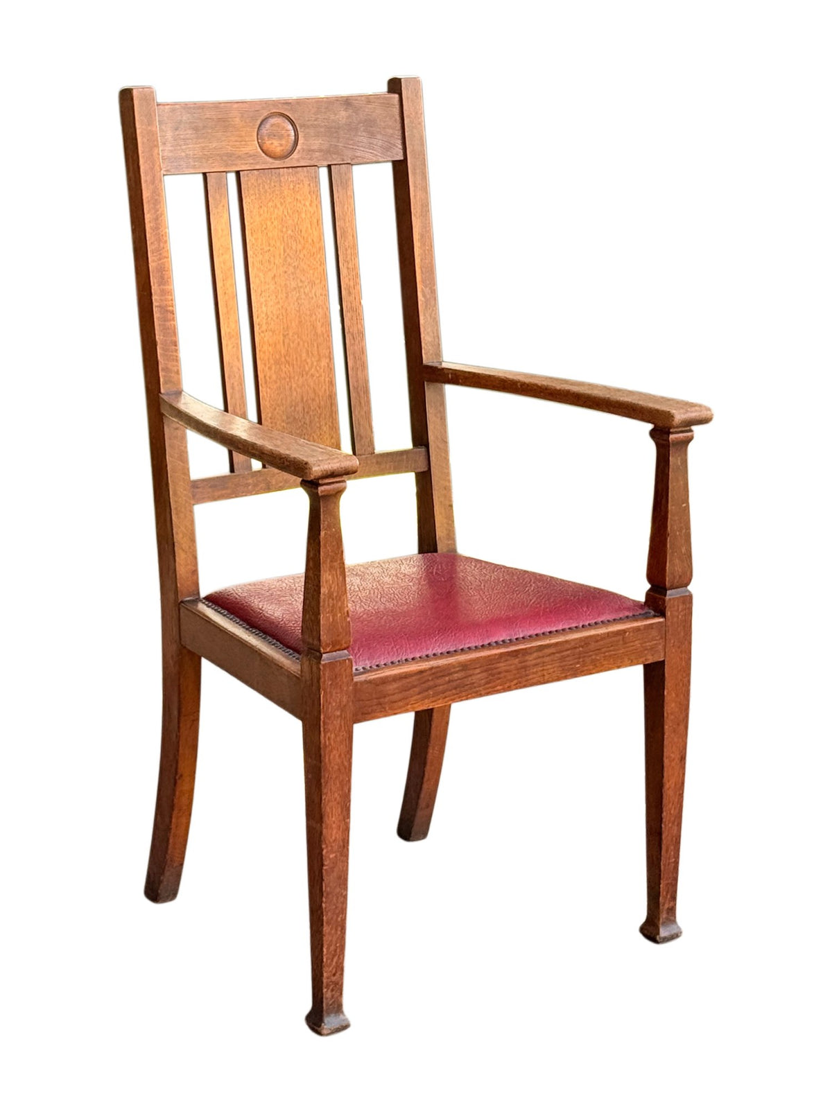 Arts & Crafts Glasgow style oak open armchair with roundel back and red leatherette drop-in seat, three-quarter view from the left