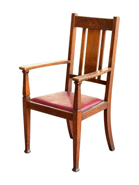 Arts & Crafts Glasgow style oak open armchair, three-quarter view from the right showing shaped arms and tapering legs