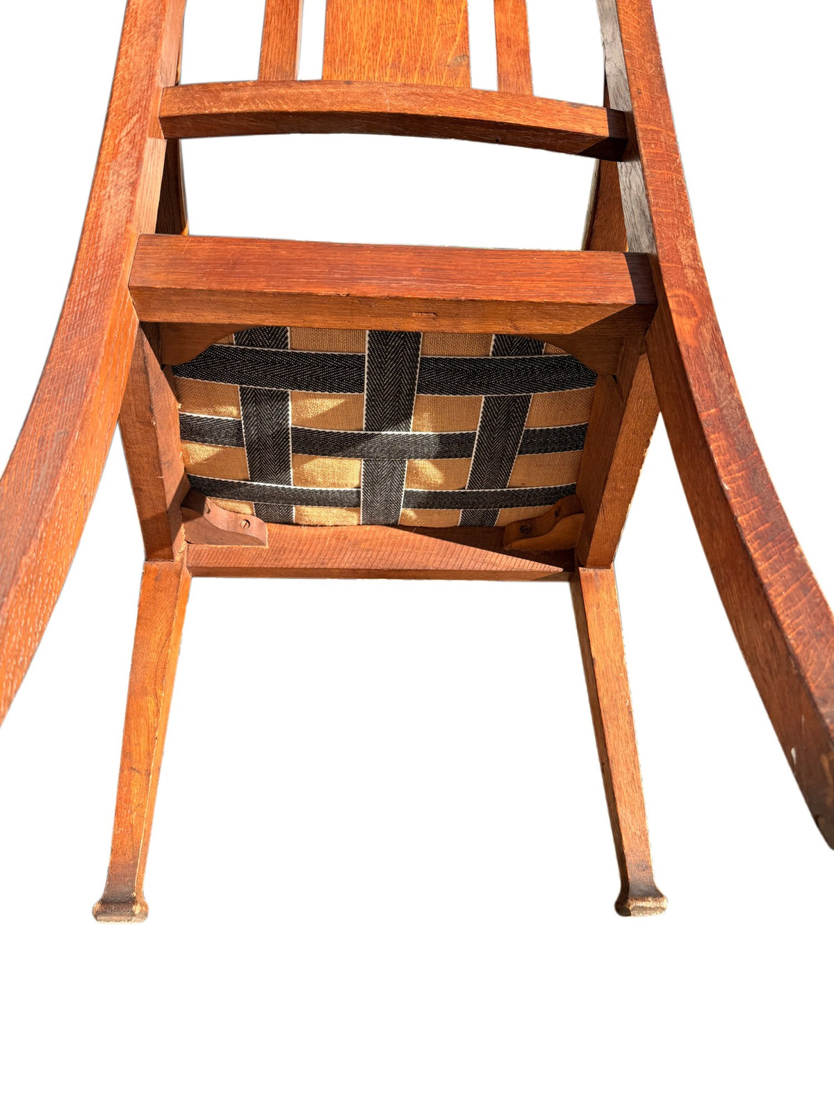 Underside of the drop-in seat showing intact webbing on Edwardian oak armchair