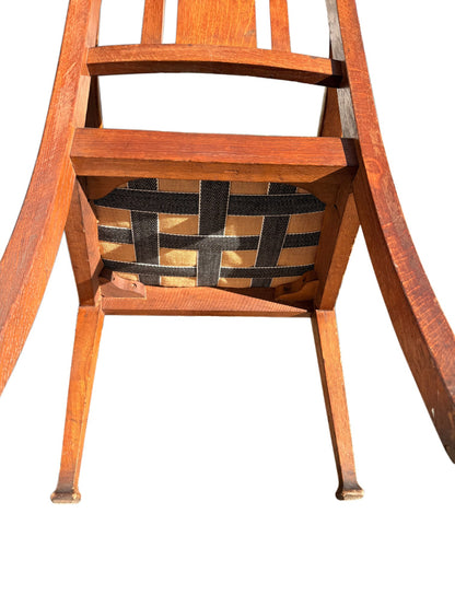 Underside of the drop-in seat showing intact webbing on Edwardian oak armchair