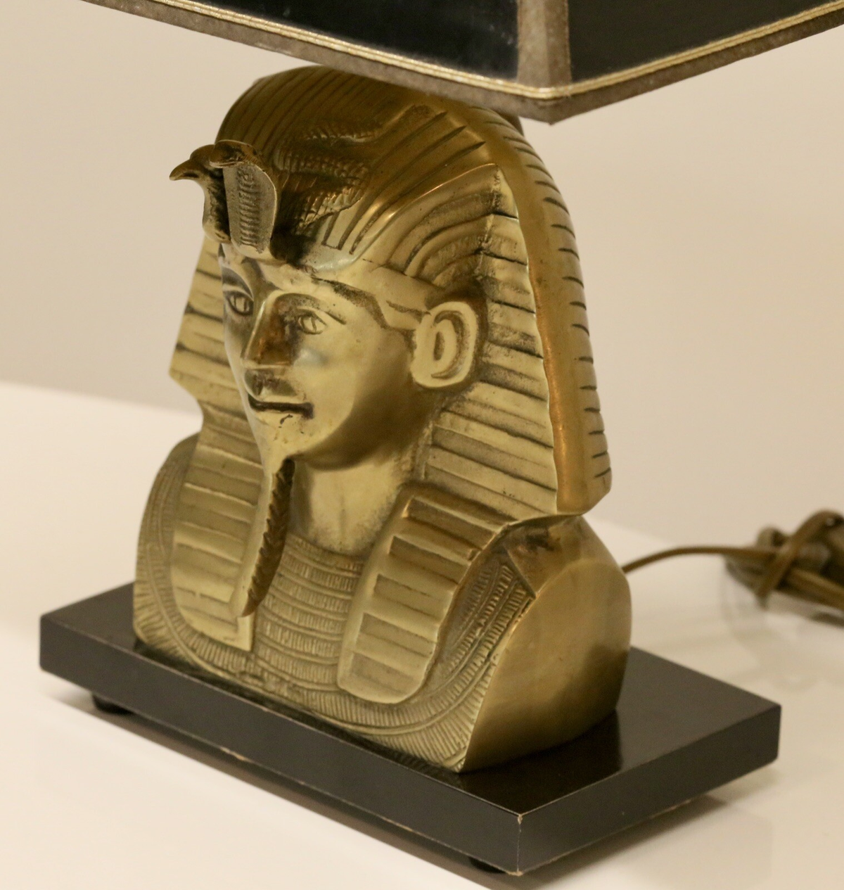 Close-up of brass pharaoh bust, three-quarter left view