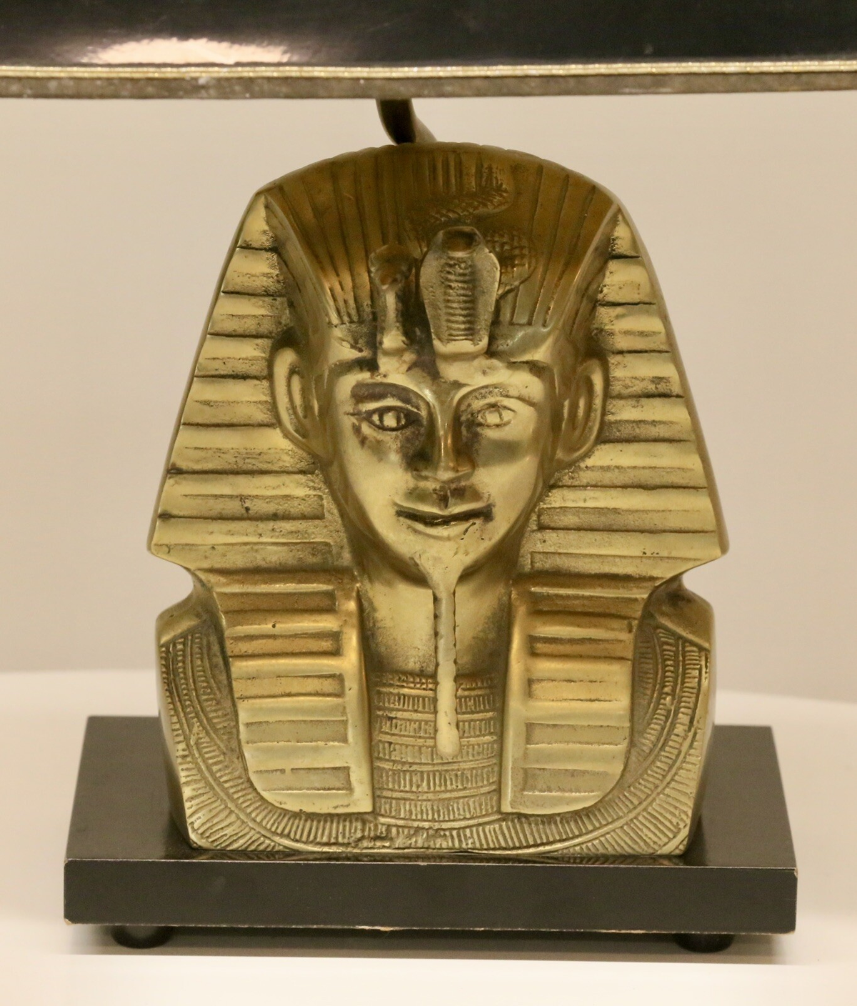 Close-up of the cast brass pharaoh head on black plinth