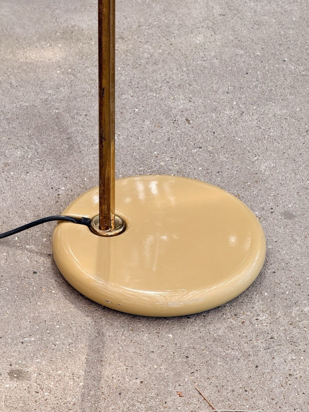 Close-up of the round cream enamel base and brass stem, Piantana floor lamp