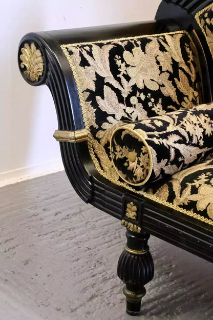 Regency couch arm, close-up of gilt roundel and reeded ebonised frame