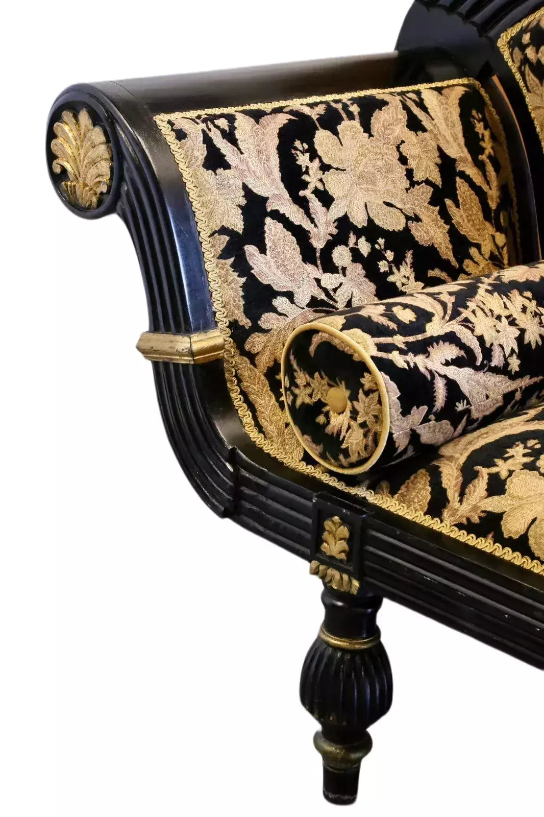Close-up of scrolled arm with gilt anthemion roundel and turned leg