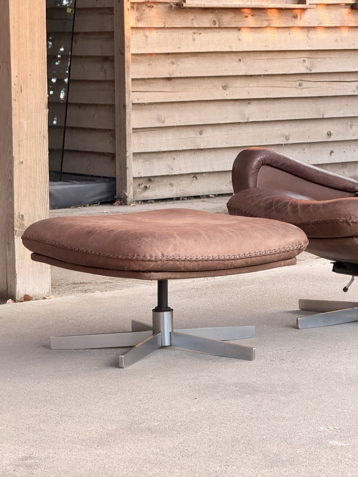 De Sede S231 ottoman, close-up of brown leather top on chrome star base