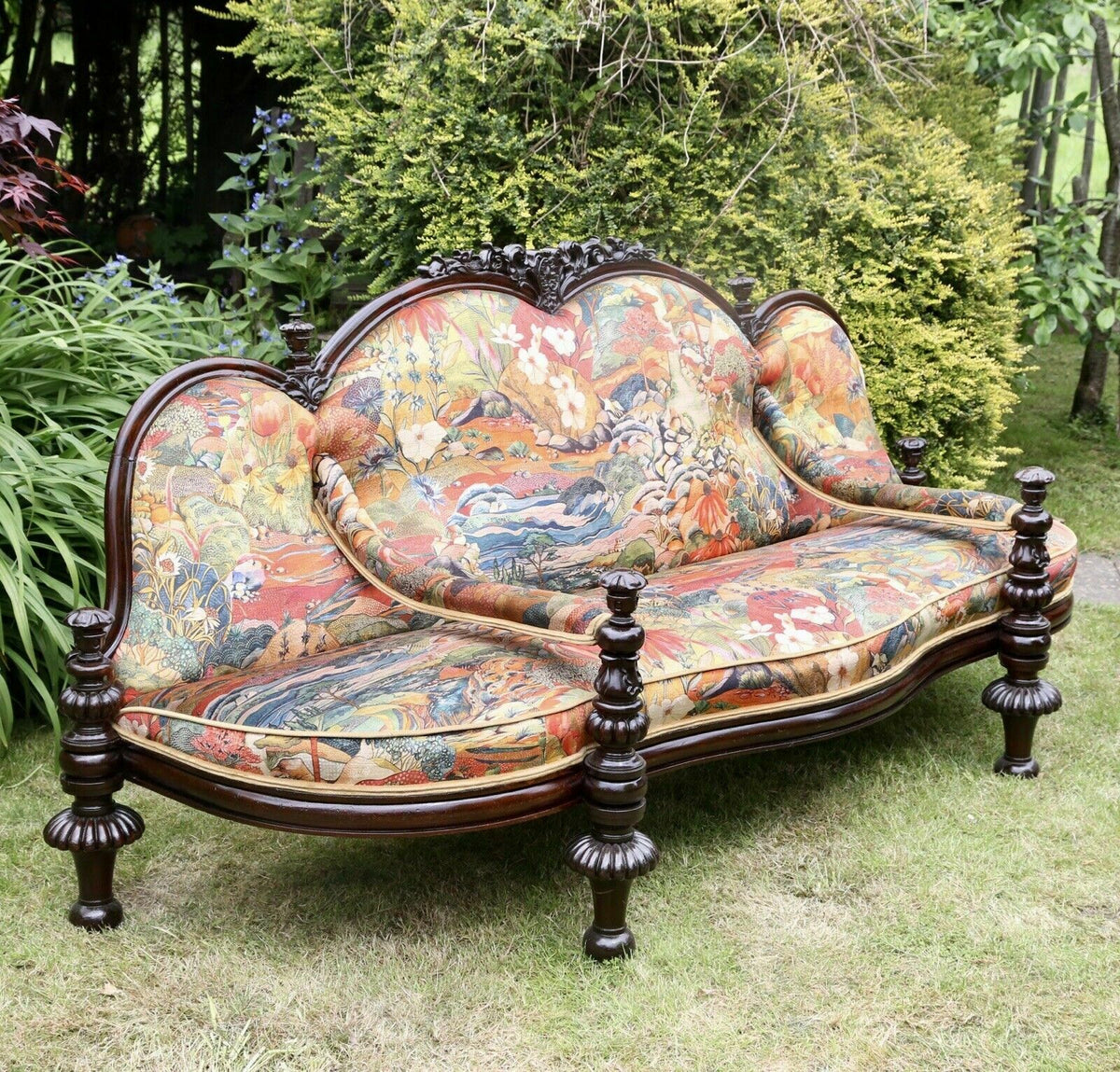 Fine Victorian carved rosewood conversation seat upholstered in colourful Osborne & Little fabric, turned legs