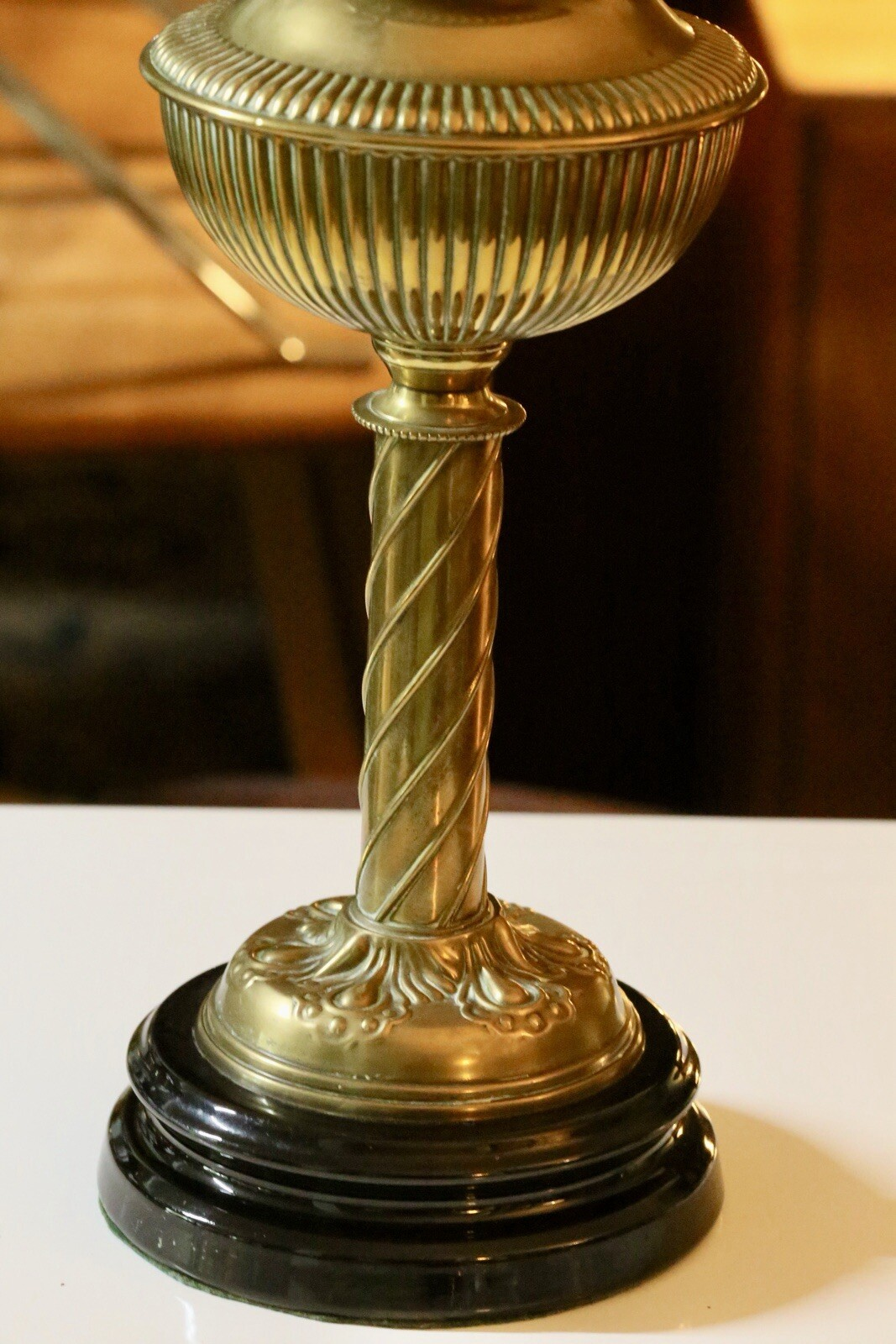 Close-up of twisted brass column and black stepped base