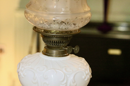 Close-up of brass burner above the embossed milk glass reservoir