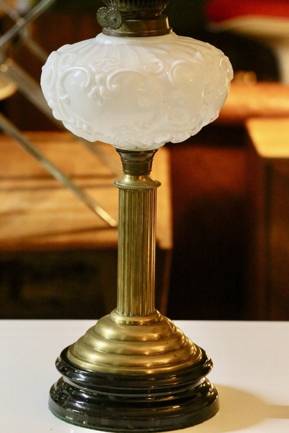 Close-up of embossed milk glass font and brass column
