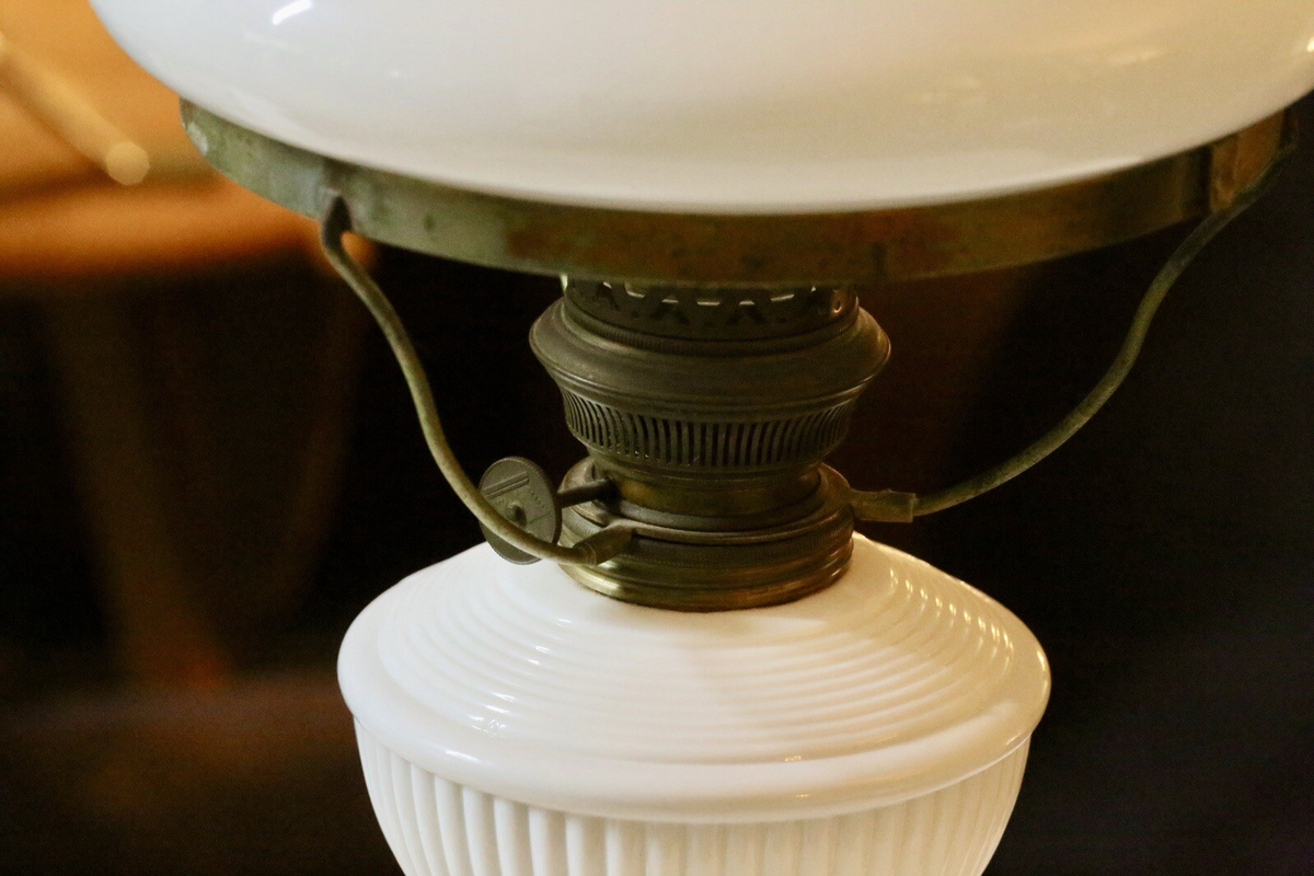 Close-up of brass burner, gallery arms and ribbed milk glass font