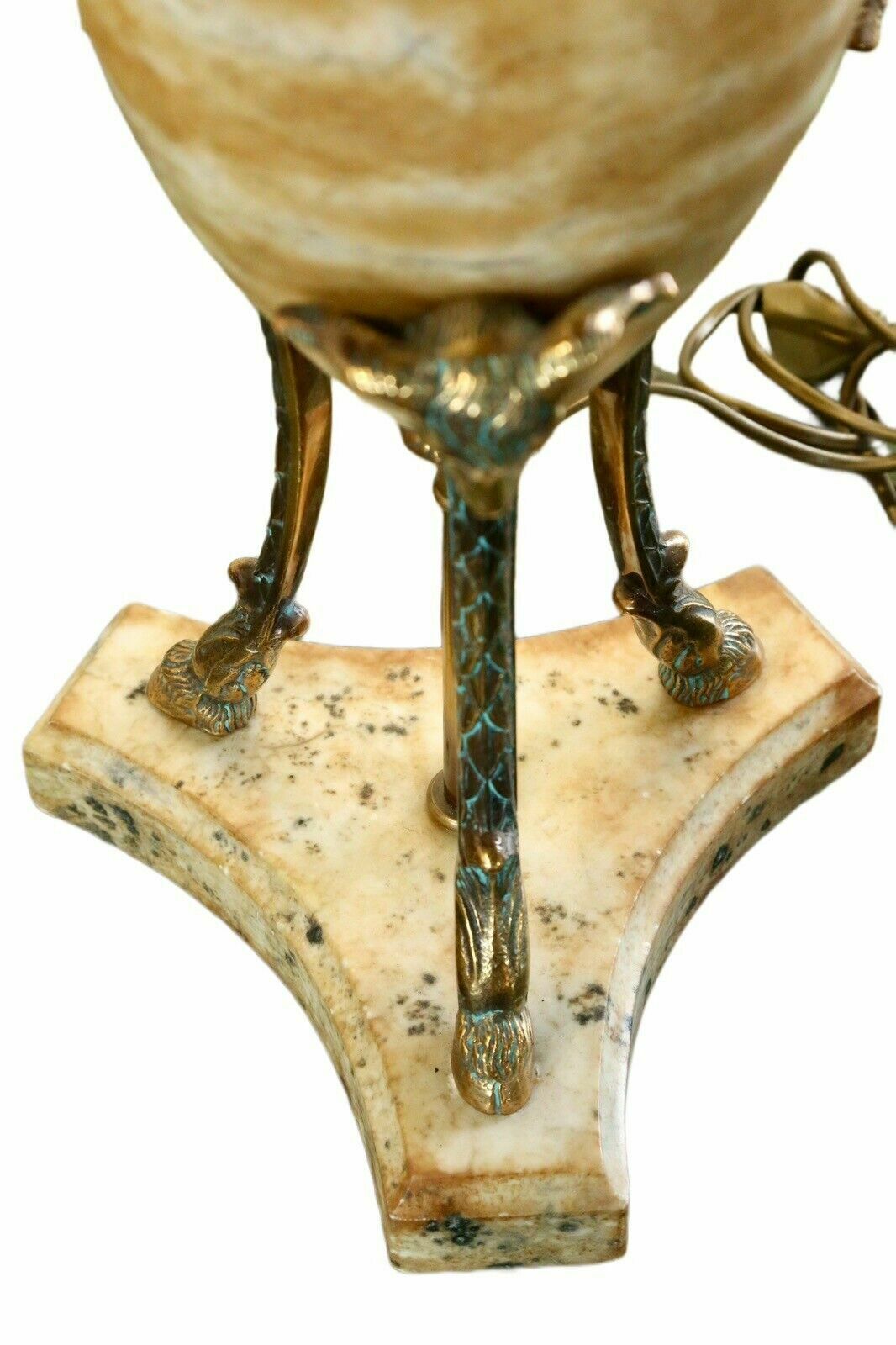 Close-up of brass hoof feet on the triangular alabaster base