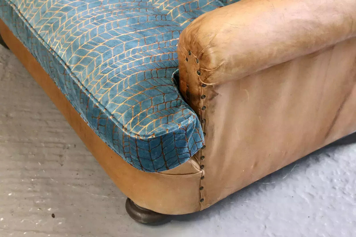 Close-up of velvet seat cushion, leather arm and bun foot
