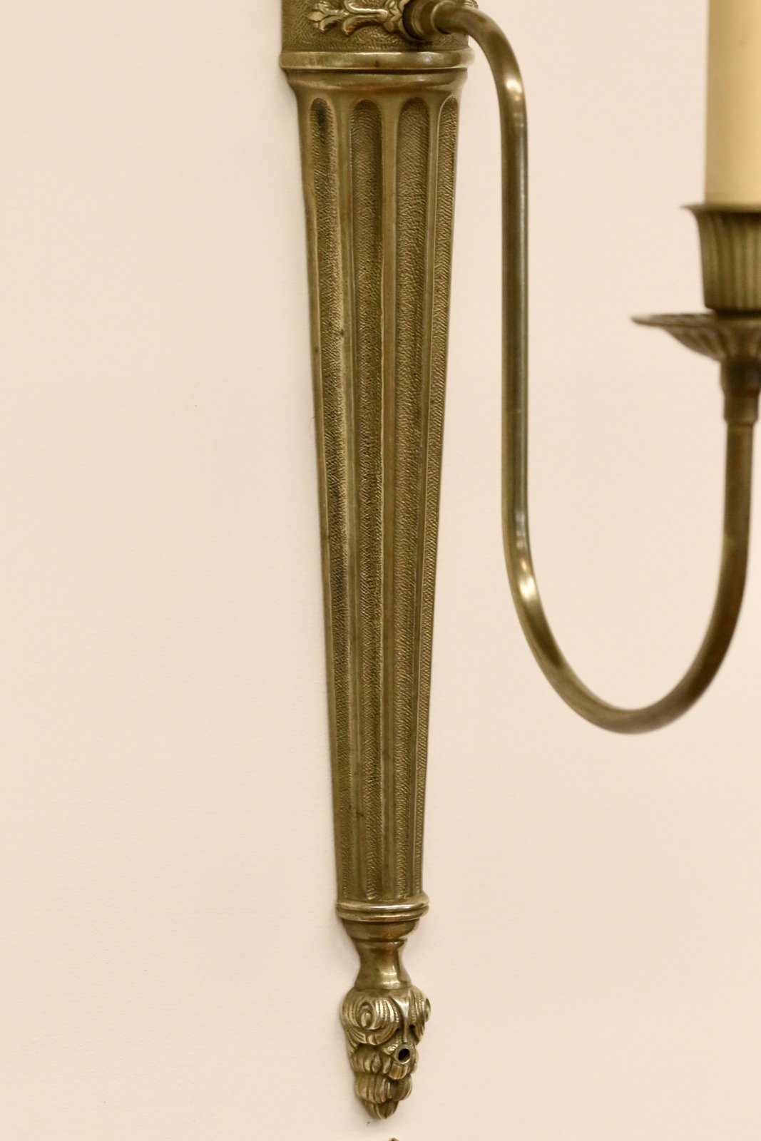Close-up of fluted backplate and curved arm, brass sconce