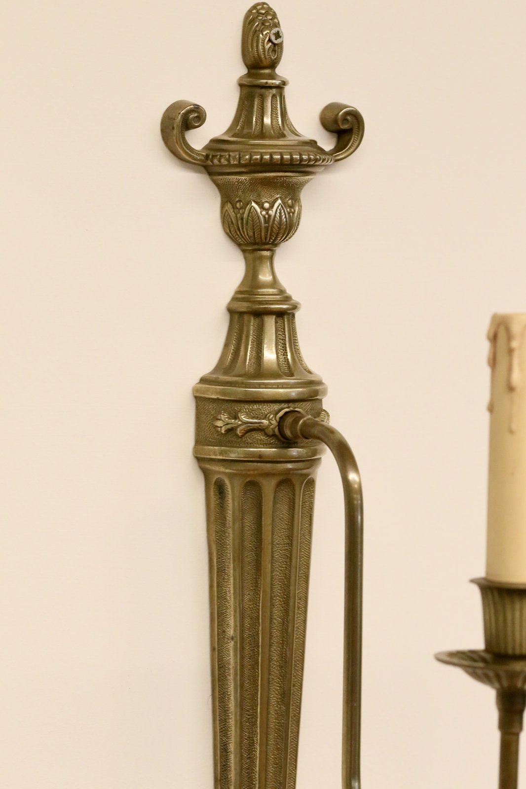 Close-up of urn finial and arm mount, neoclassical sconce