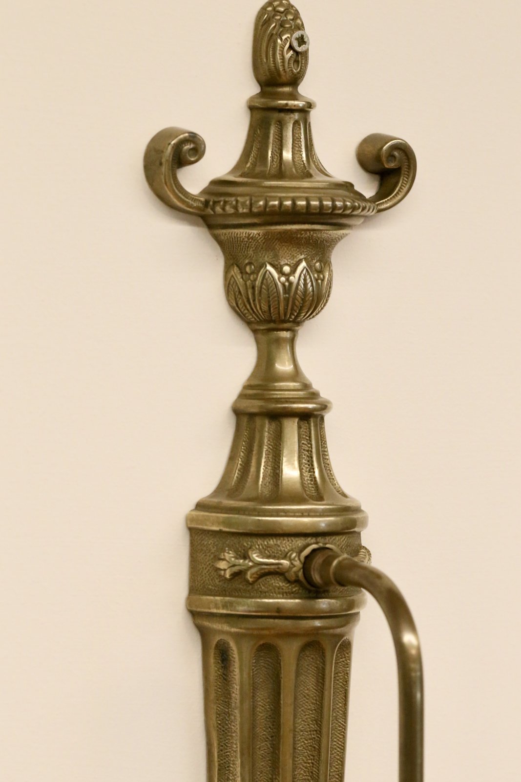 Close-up of urn finial with leaf decoration, French brass sconce