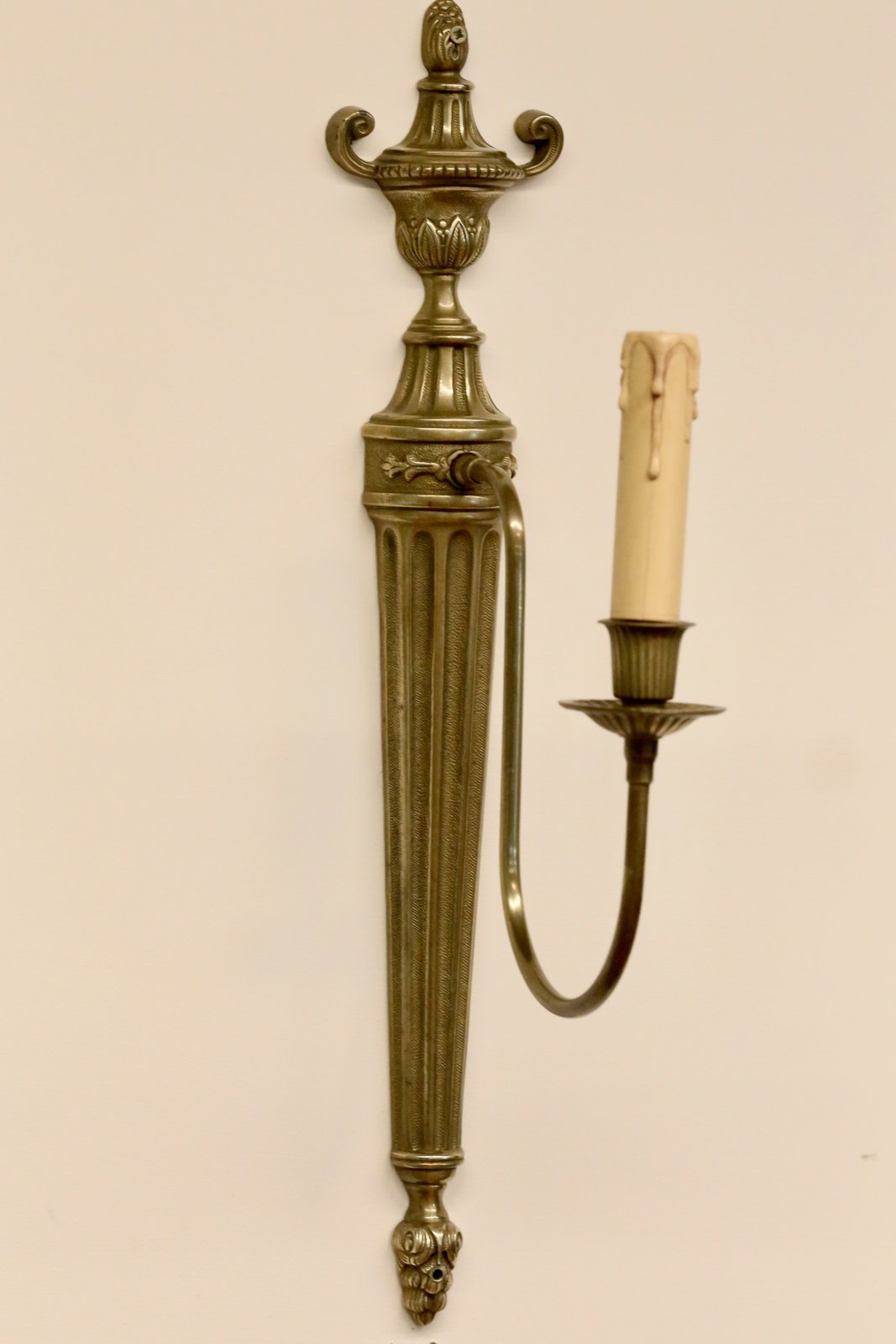 French neoclassical brass wall sconce, angled view with arm on the right