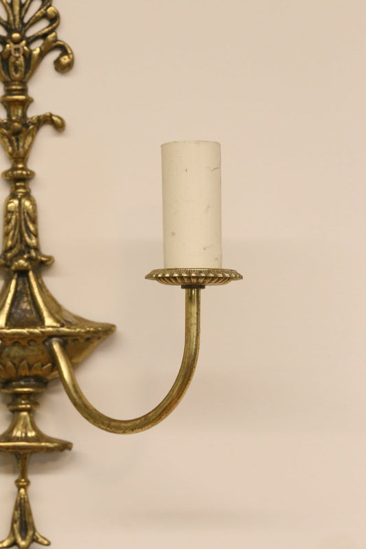 Close-up of scrolled brass arm and candle sleeve, French Empire sconce