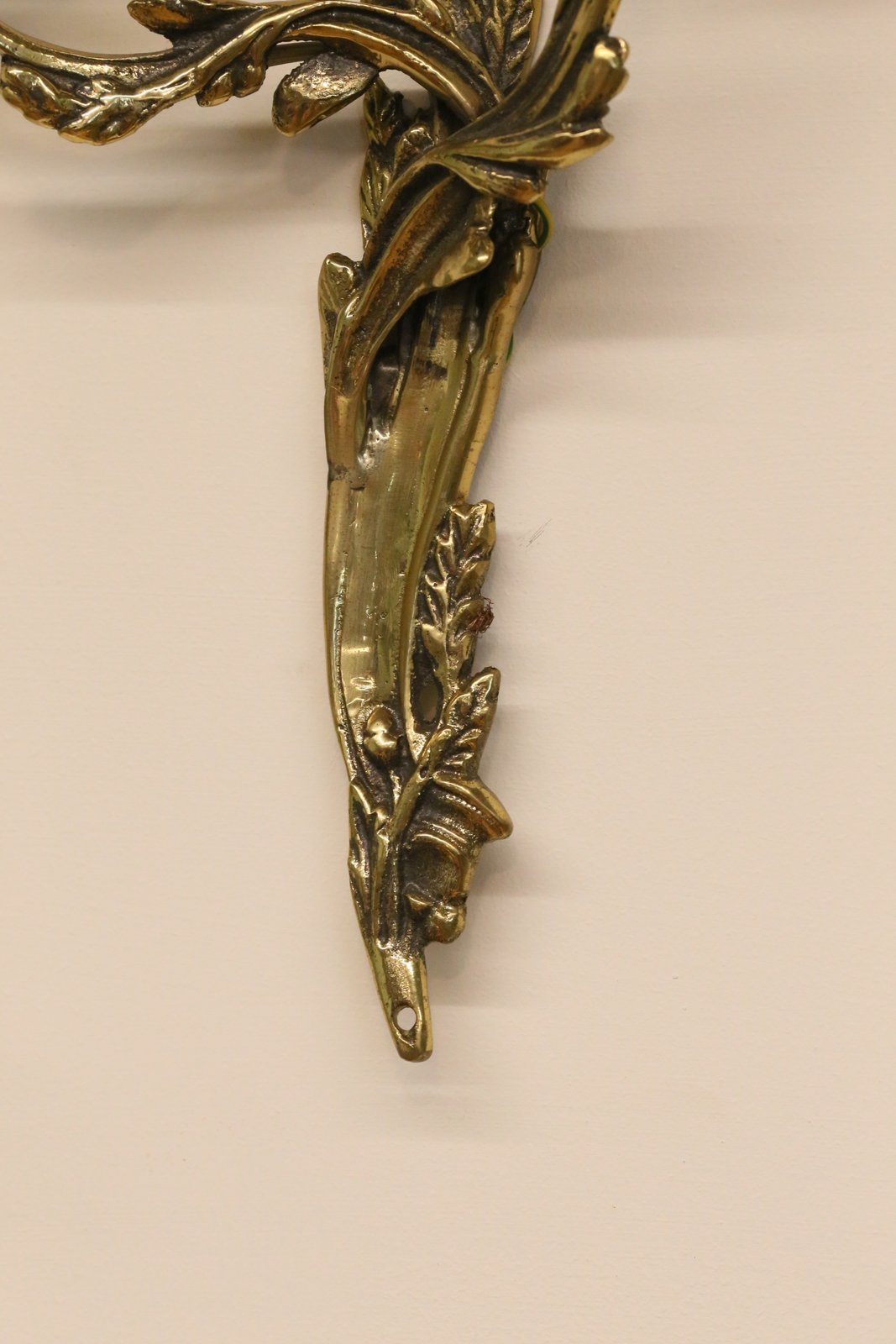 Close-up of cast foliate backplate, gilt brass wall sconce