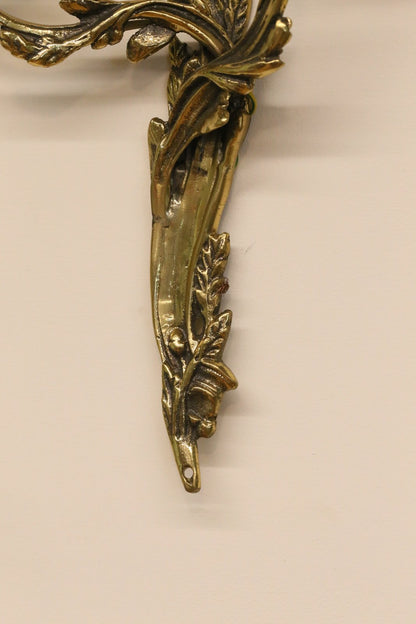 Close-up of cast foliate backplate, gilt brass wall sconce