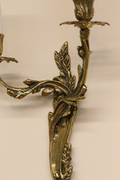 Close-up of scrolled arm and leaf detail, gilt brass sconce