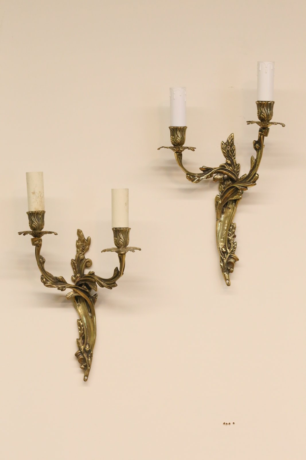 Pair of Louis XV style gilt brass wall sconces on a wall
