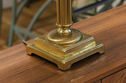 Close-up of square stepped brass base and fluted column