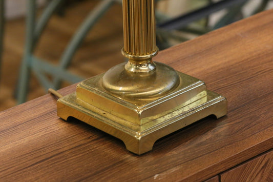 Close-up of square stepped brass base and fluted column