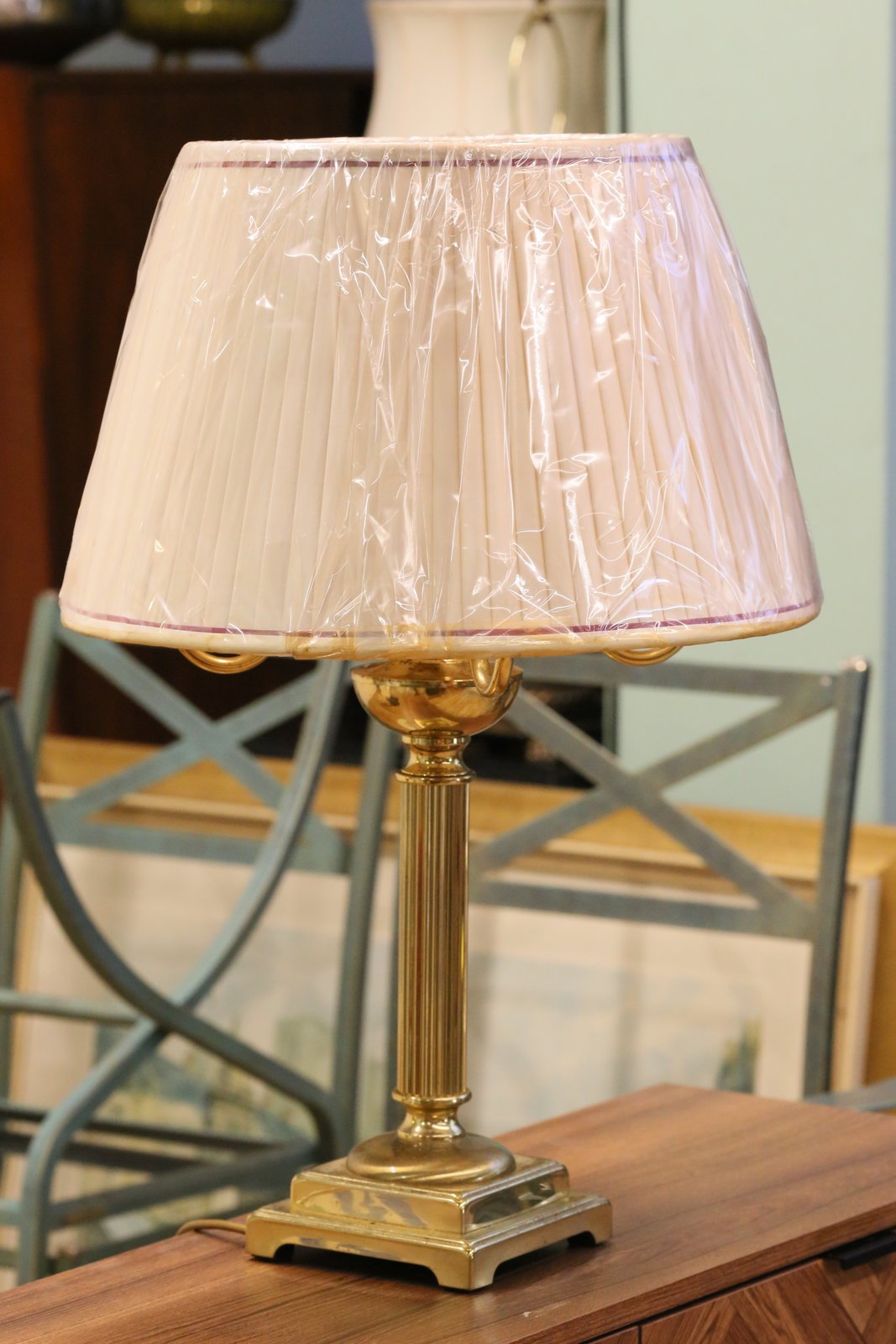 Vintage brass candelabrum table lamp with shade, on a sideboard