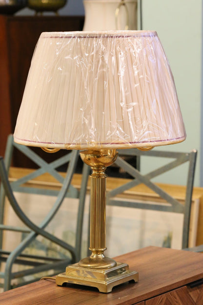 Vintage brass candelabrum table lamp with shade, on a sideboard