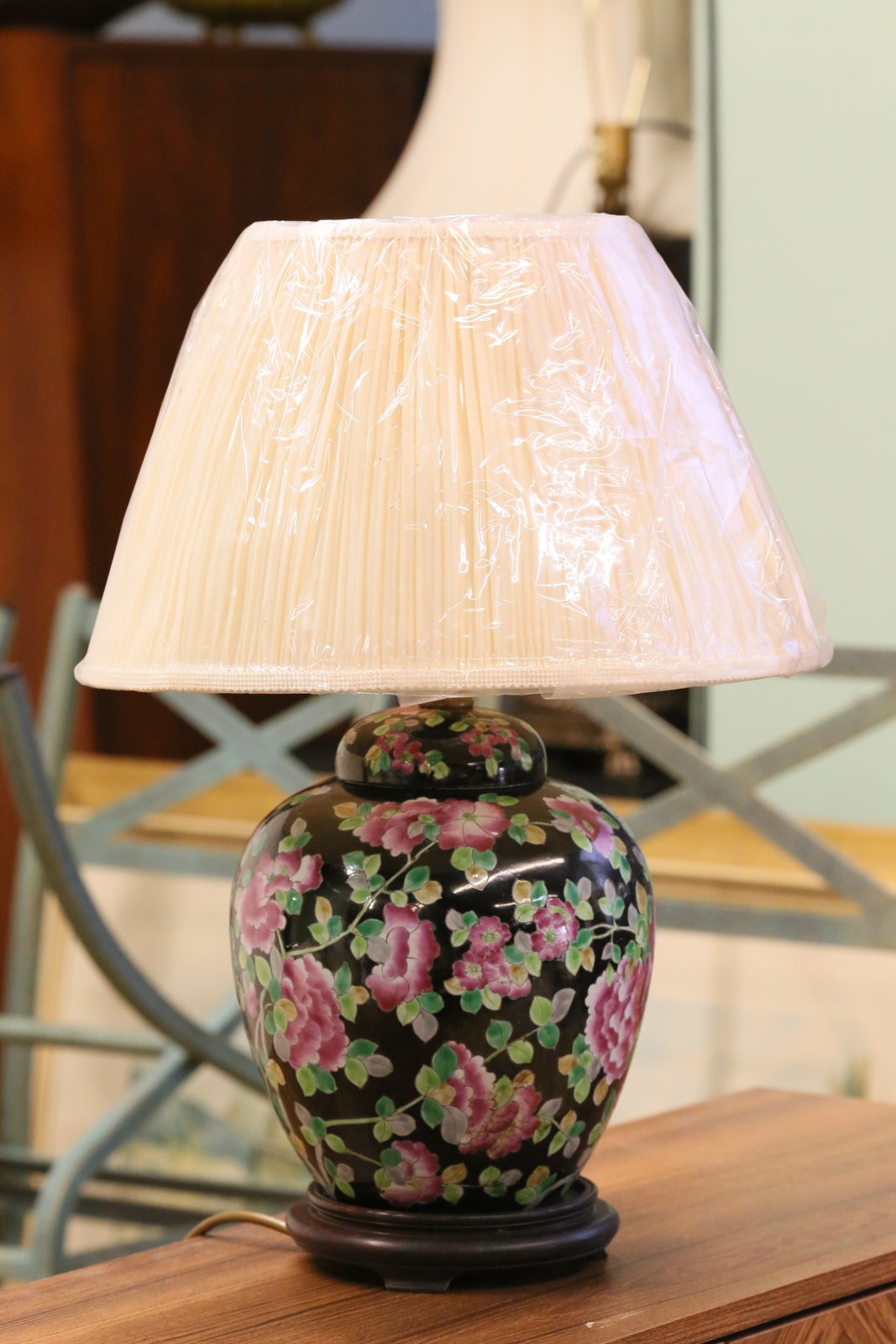 Chinese porcelain floral table lamp with cream shade on a sideboard