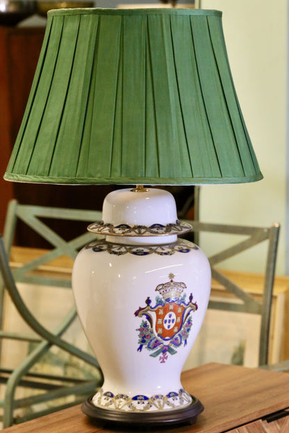 Antique Chinese porcelain lamp with armorial crest and green pleated shade, front view