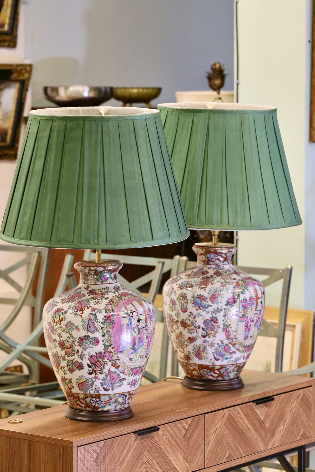 Pair of famille rose lamps with green shades on a sideboard