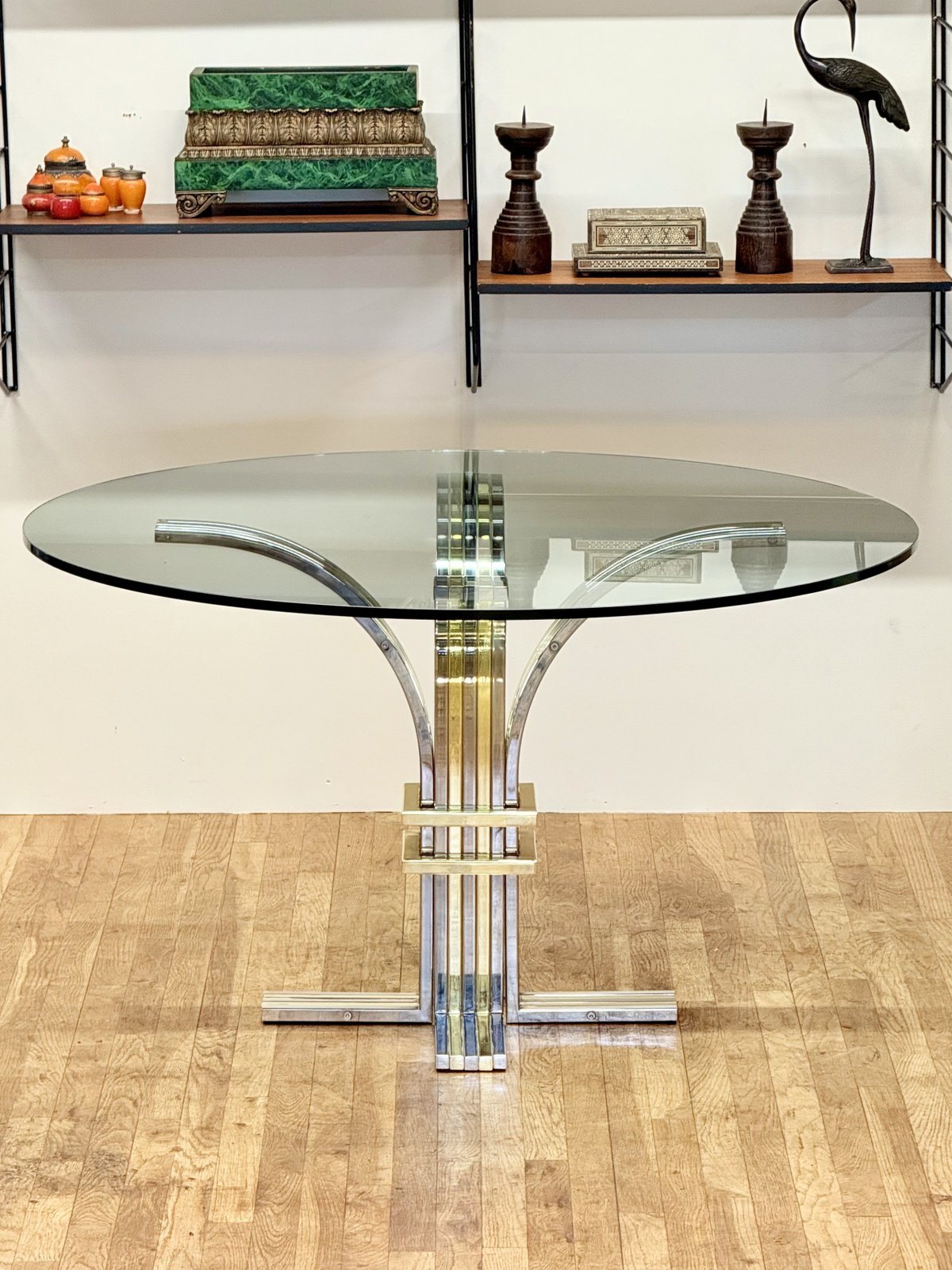 Renato Zevi chrome and brass glass centre table in a room with wall shelving