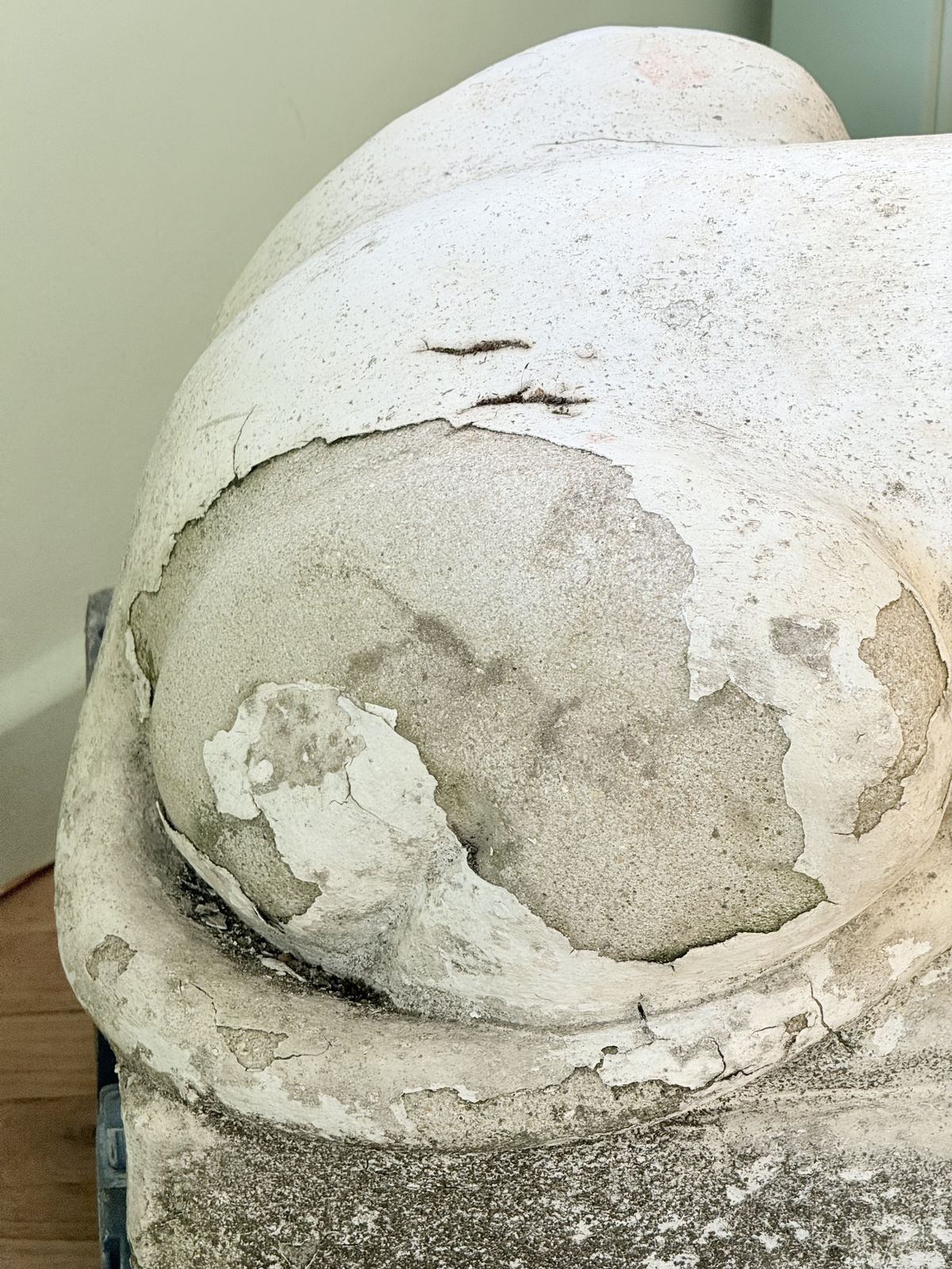 Close-up of weathered painted surface on the cast stone lion's haunch