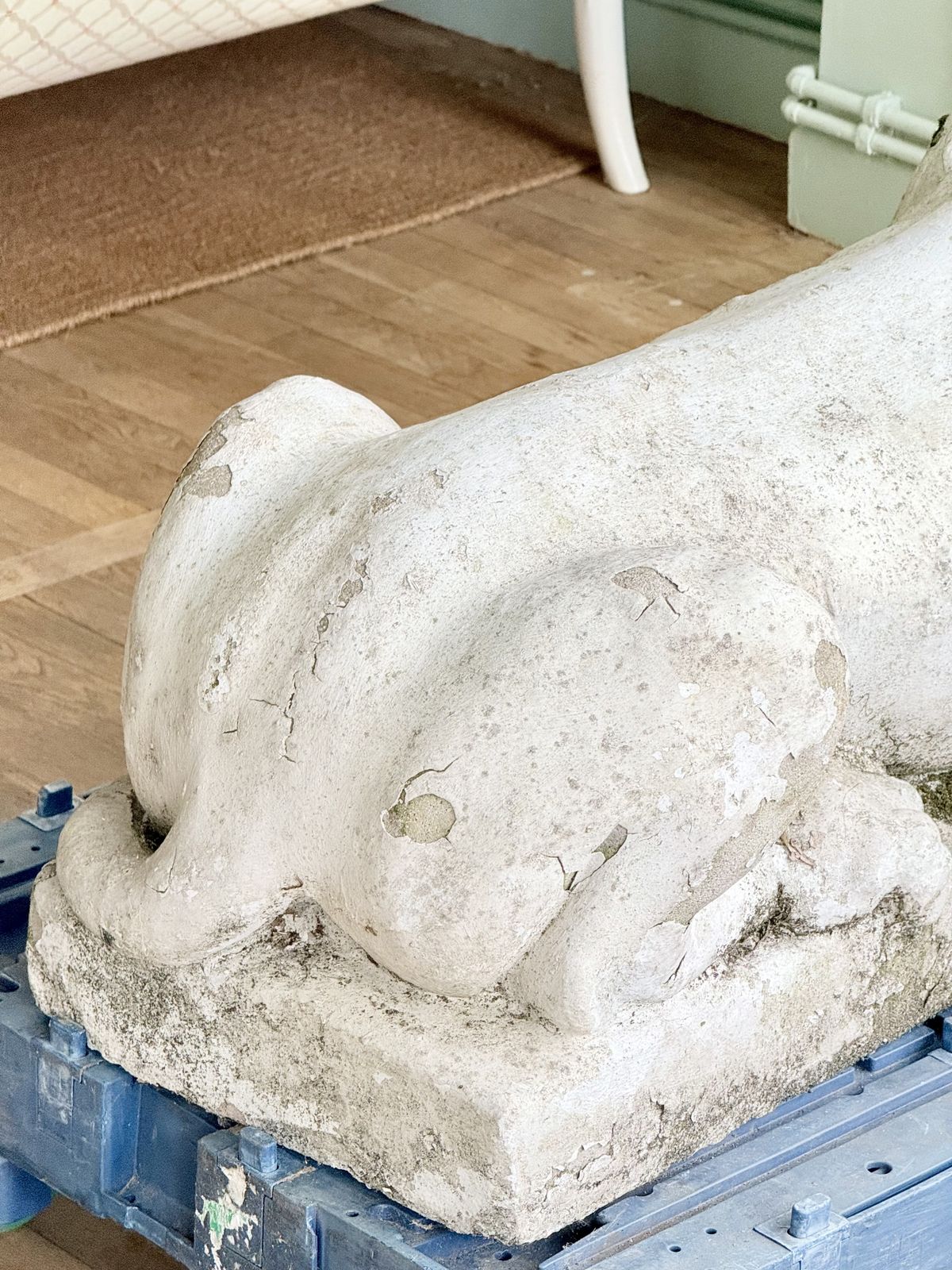 Close-up of lion haunch and paw, weathered cast stone