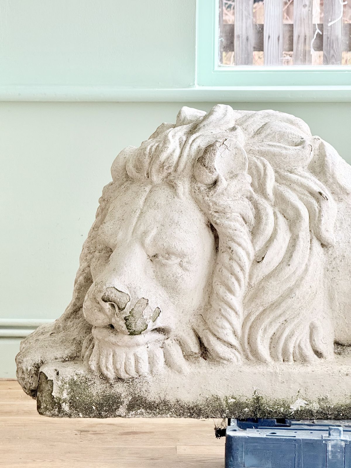 Close-up of sleeping lion head and paws, cast stone